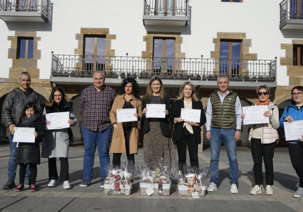 Los ganadores del concurso de escaparates junto a las vecinas premiadas con los bonos de compra tras la presentación.