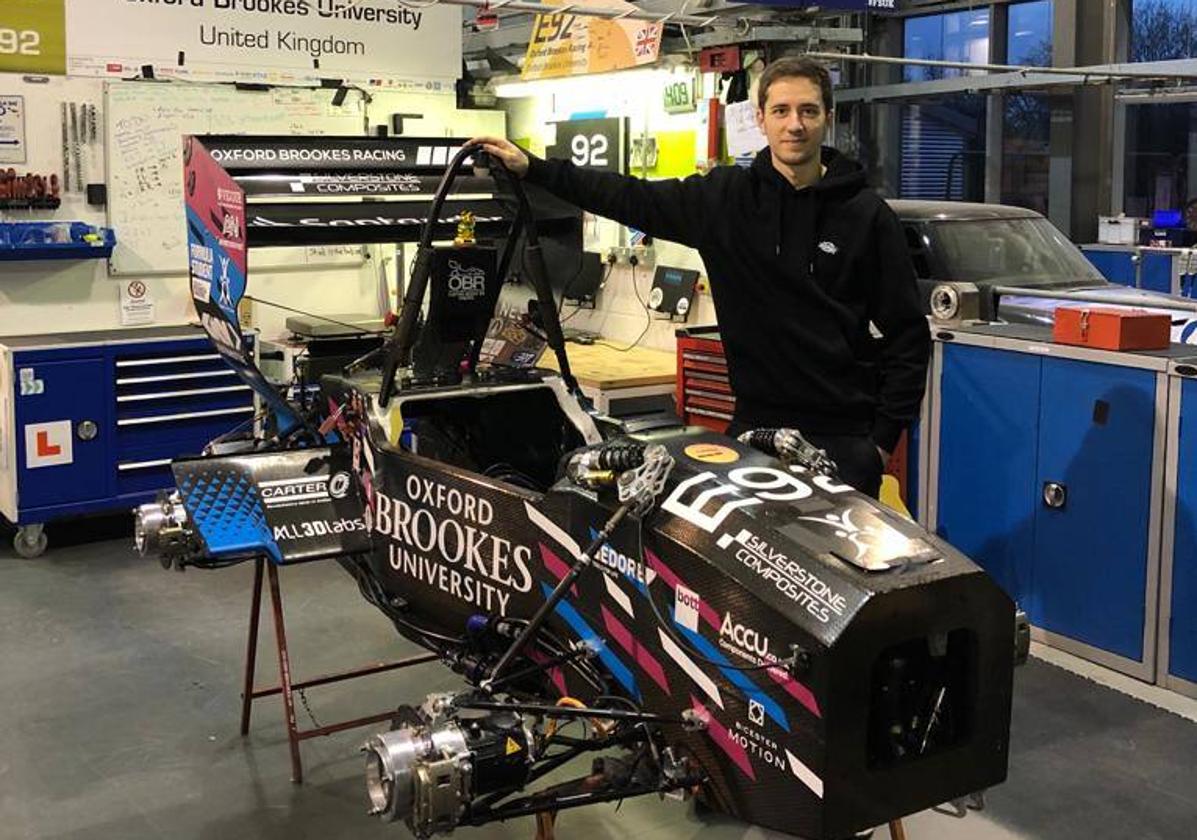 Turrientes posa en el taller del Formula Student en la universidad de Brookes junto a un cochesobre el que trabajan.