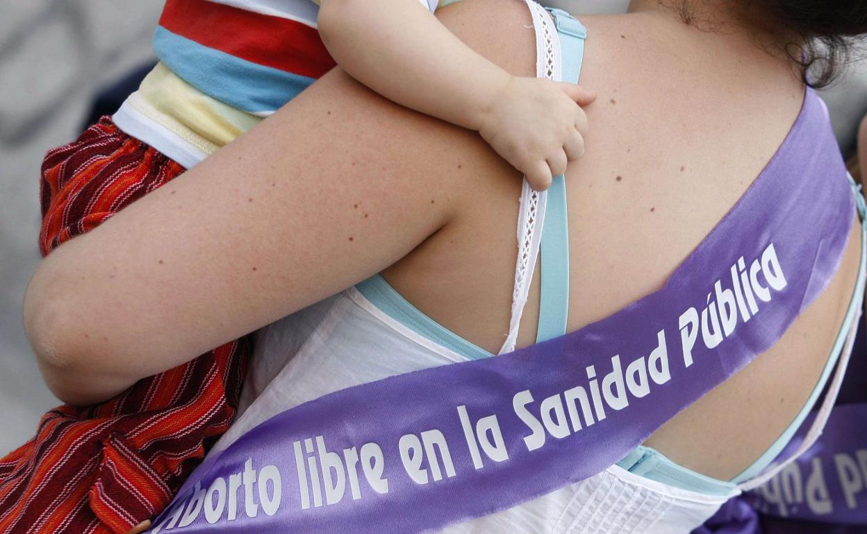 Una madre porta una banda en defensa del aborto libre en centros sanitarios públicos. 