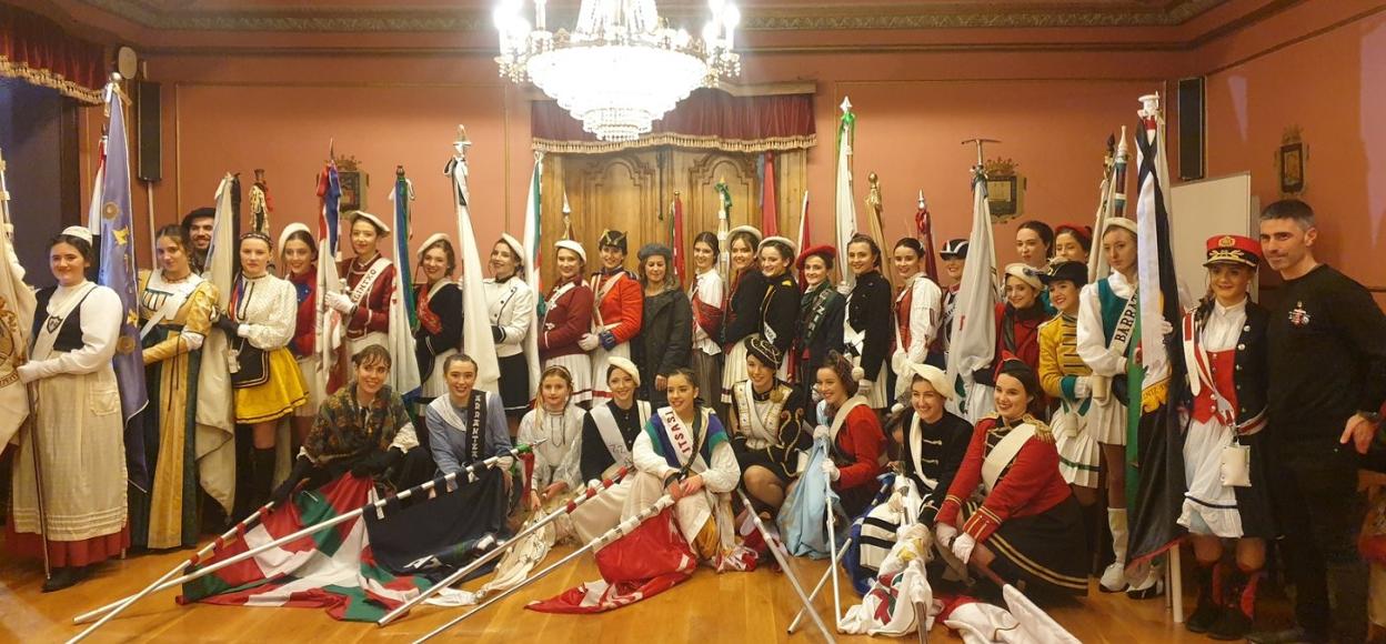 San Sebastian bezperako danborradan parte hartu zuten banderadunak udaletxeko areto nagusian udal ordezkariekin. 