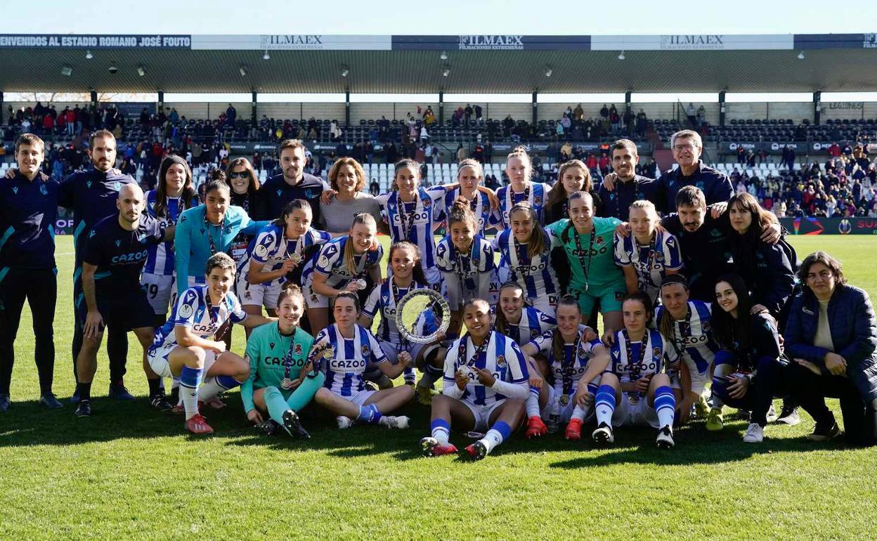 La plantilla txuri-urdin posa con el trofeo de subcampeonas y las medallas.