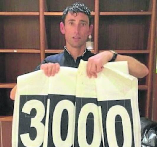 Abajo, posando con el número 3.000 tras conseguir ese guarismo de victorias.
