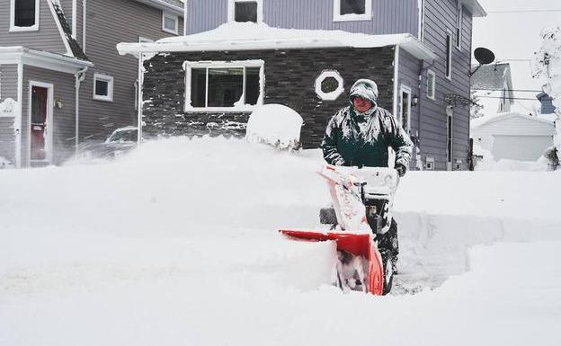 A man removes snow left behind by the storm that affected much of the United States in December 2022