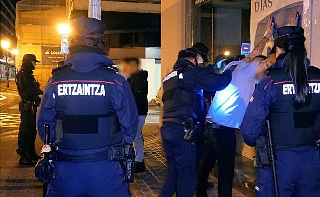 Agentes de la Ertzaintza cachean a varios jóvenes en el exterior de la discoteca bilbaína. 