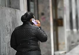 Una mujer habla por su teléfono móvil mientras pasea por la calle en Donostia.