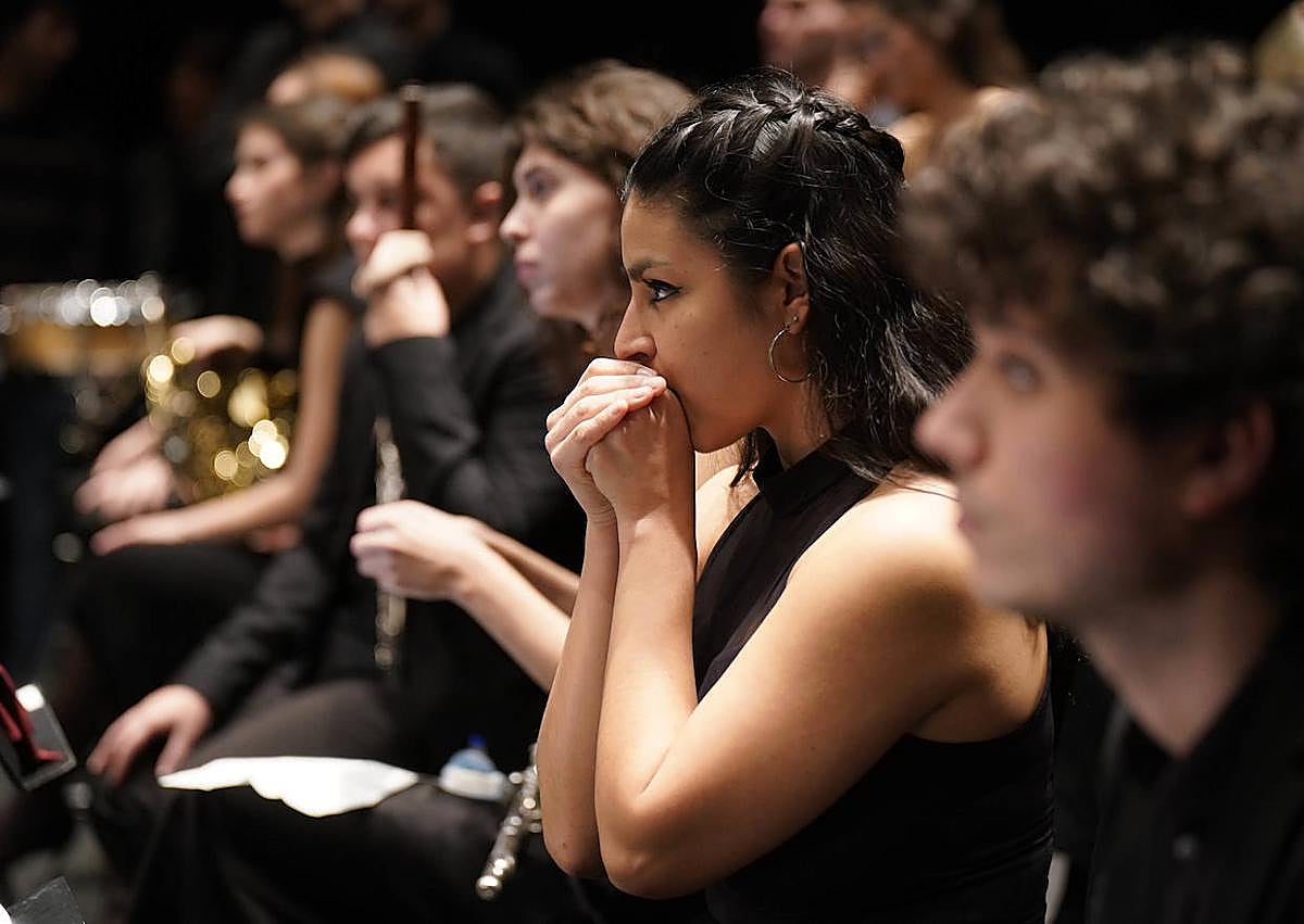 Imagen secundaria 1 - Los protagonistas no quisieron dejar pasar la oportunidad de inmortalizarse con el anfiteatro de fondo, antes de un concierto en el que muchos de ellos se estrenaban. La sección de vientos atiende a las explicaciones del director durante el ensayo general en el teatro donostiarra. Bromas, risas y abrazos al caer el telón.