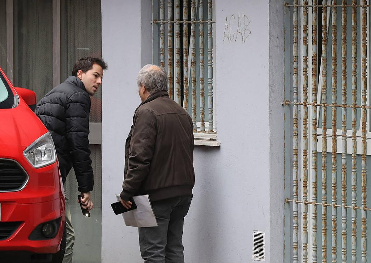 Imagen secundaria 1 - Cartel de la Ertzaintza pidiendo a los vecinos afectados que denuncien. Dos vecinos evaluaban ayer los daños provocados por el fuego.. La viviend afectada por el incendio.