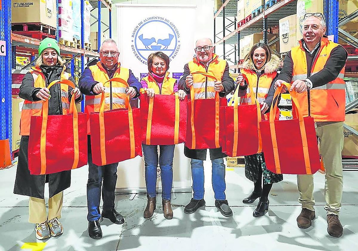 Representantes de la Diputación Foral, el Zinemaldia, el Banco de Alimentos y Emaús posan con las bolsas.