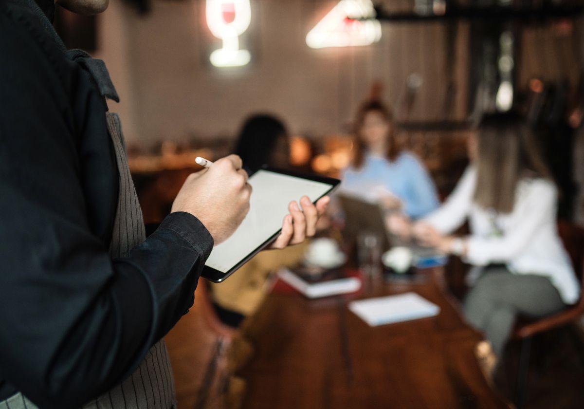 Un camarero atiende a sus clientes dentro de un restaurante