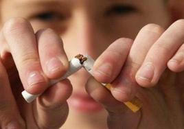 Un joven muestra su intención de poner fin a su relación con el tabaco rompiendo un cigarrillo.