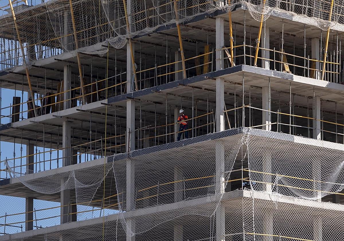 Un trabajador, en un gran edificio en construcción.