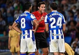 Munuera Montero da explicaciones a Mikel Merino y Robin Le Normand.