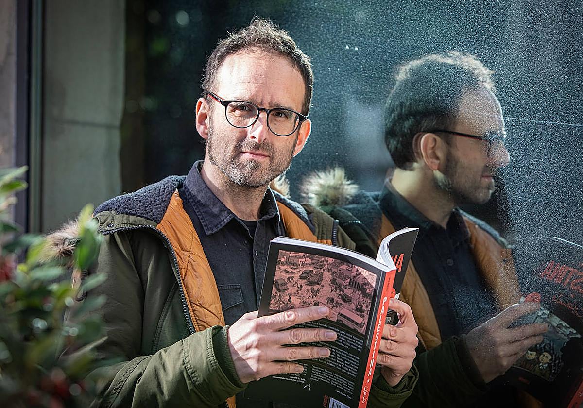 Julen Gabiria itzultzailea Joe Saccoren 'Palestina' eskuan duela.