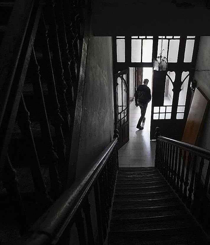 Imagen secundaria 2 - Imagen de la escalera de la que se accede a las tres viviendas superiores de la casa de la calle Matxaria. Una de las habitaciones del piso y el portal del edificio.