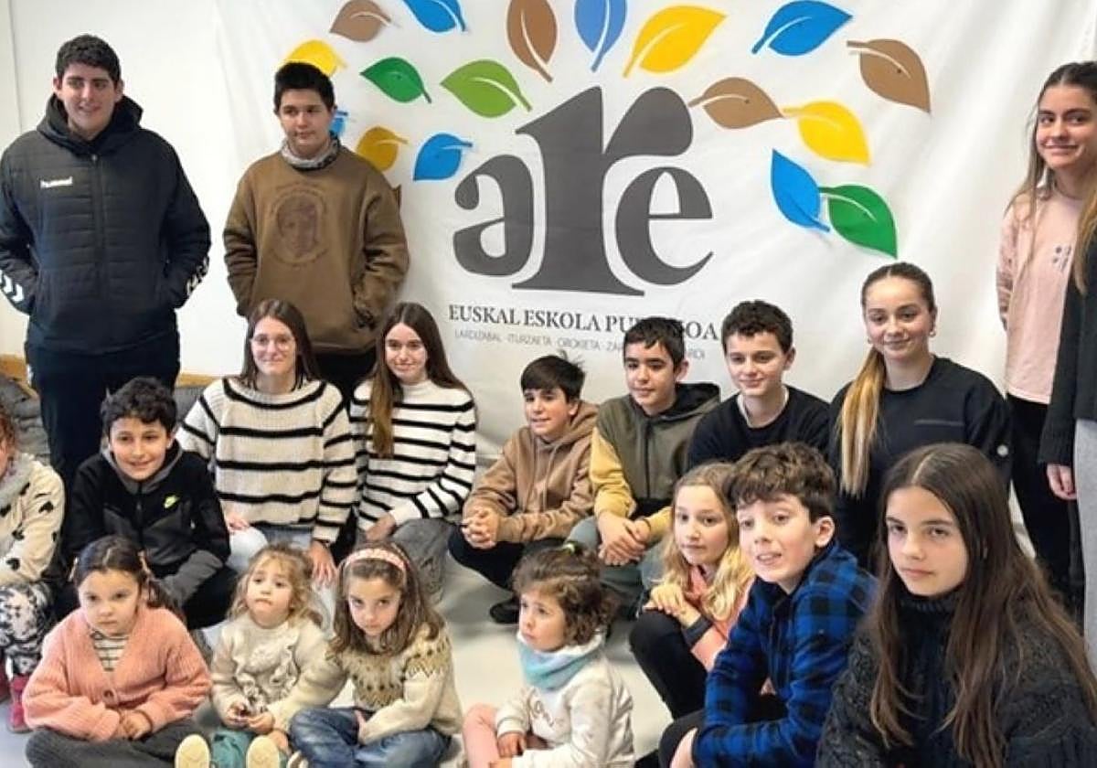 Ikasleak talde sortu berriaren logoa atzean dutela.