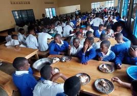 Jóvenes estudiantes del centro educativo de Gihara recobran fuerzas en el comedor del centro educativo.