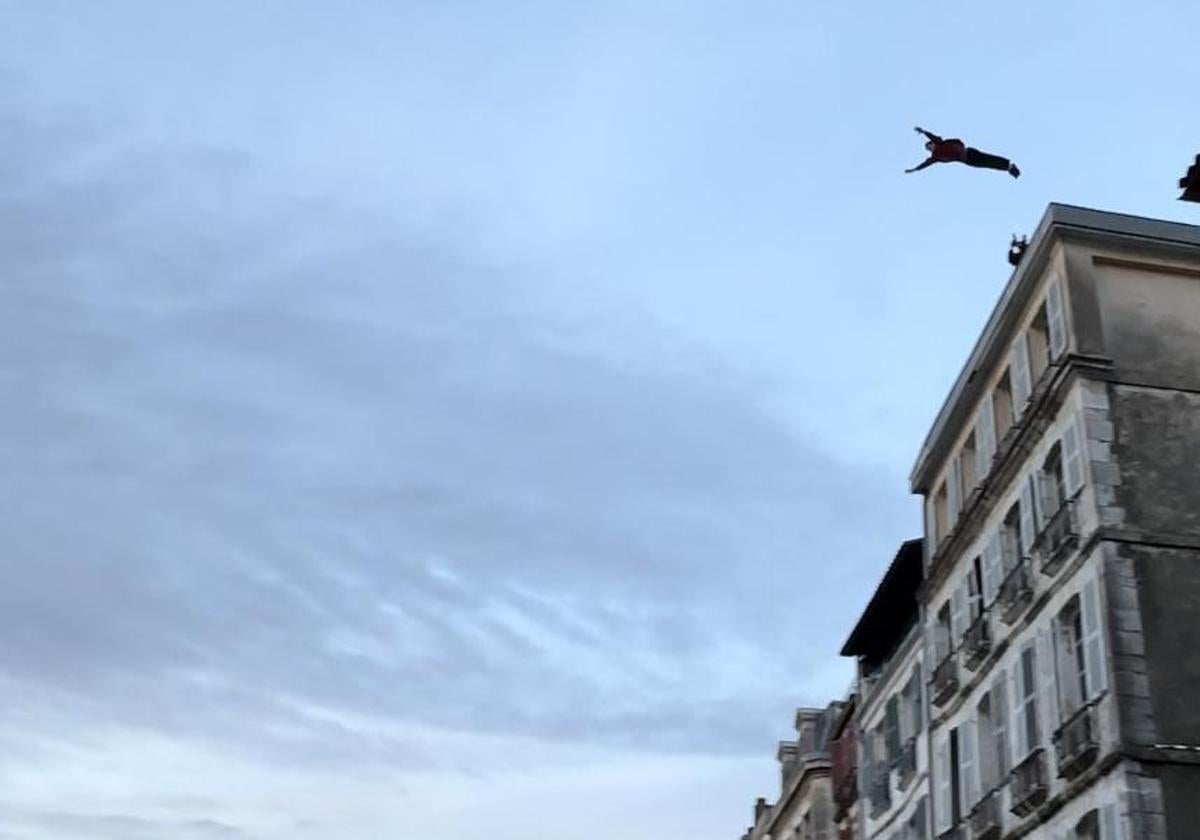 Brice Poule, en pleno salto sobre el río en el centro de Baiona.