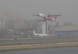 Un avión despegando del aeropuerto de Hondarribia con bastante niebla.