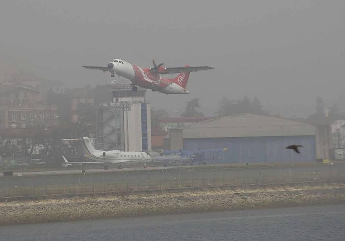 Un avión despegando del aeropuerto de Hondarribia con bastante niebla.