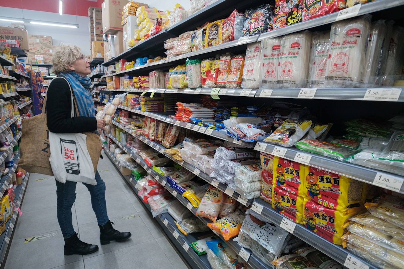 La oñatiarra Isabel Moreno mirando una de las estanterías del supermercado con varias raíces de loto en la mano.