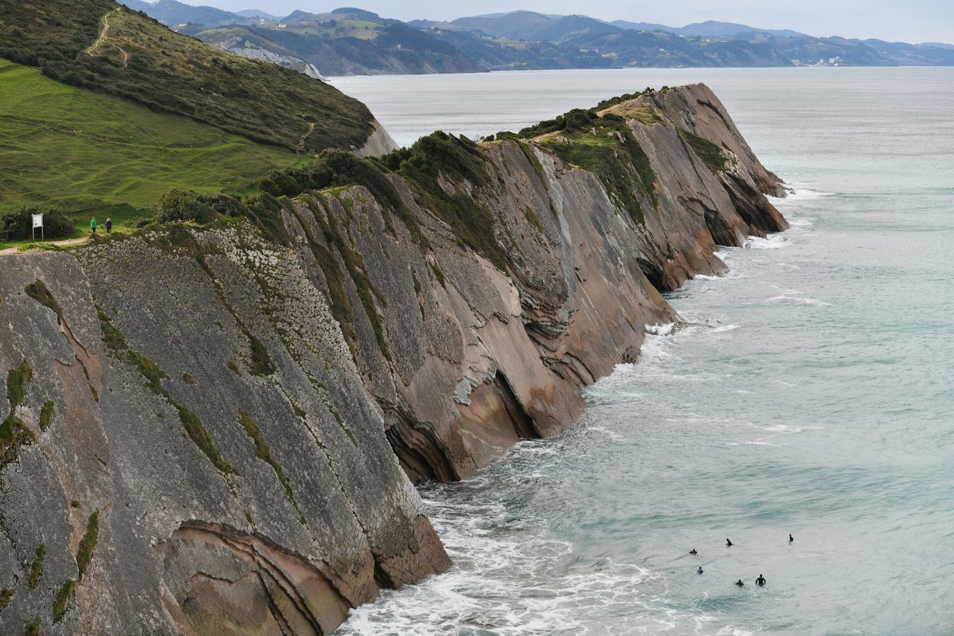 Surfistas al lado del flysch