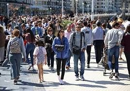 Paseantes en una mañana soleada por La Concha.