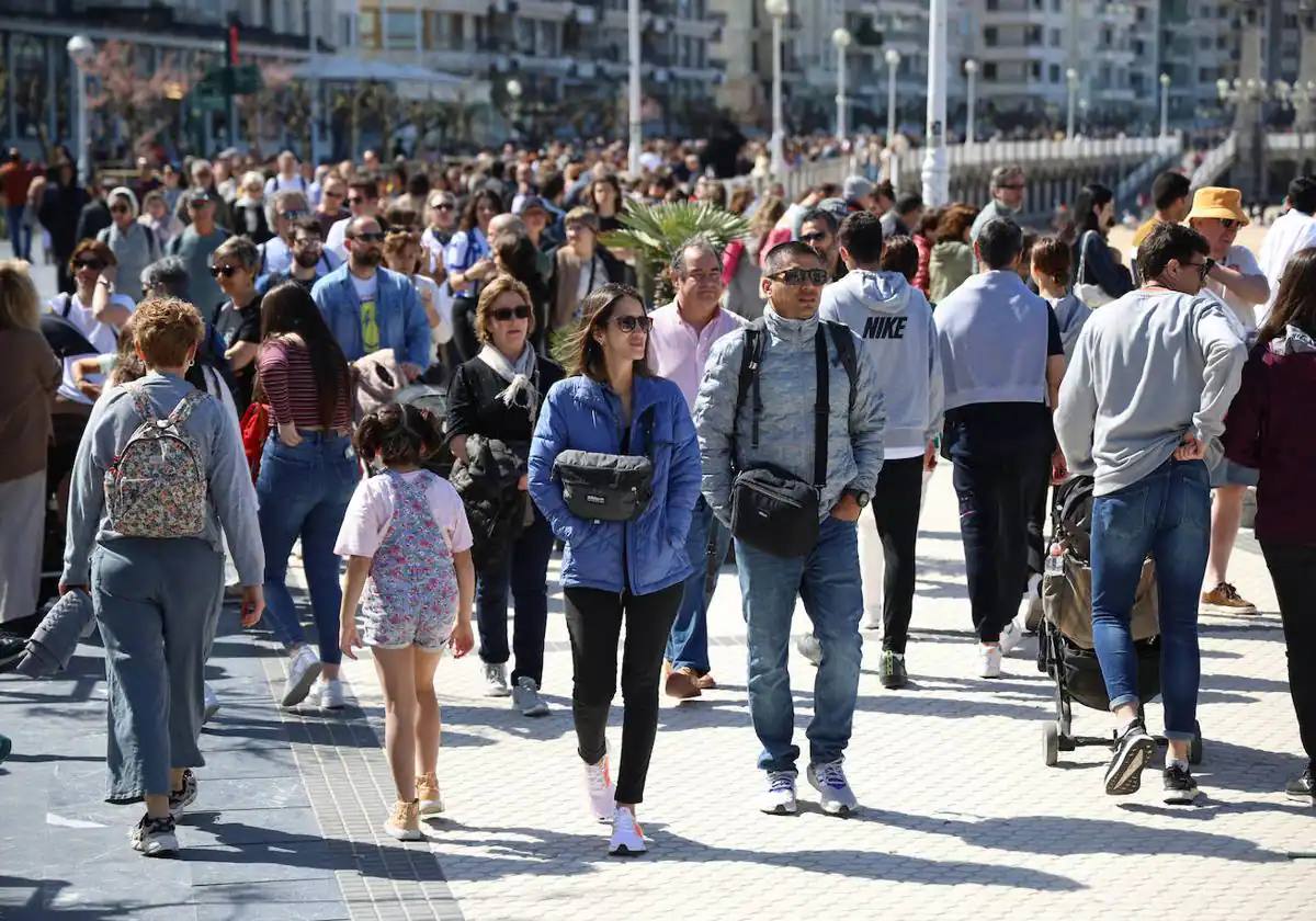 Paseantes en una mañana soleada por La Concha.