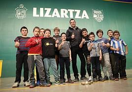 Erik Jaka, rodeado de varios pelotaris a los que entrena en su pueblo, en Lizartza.