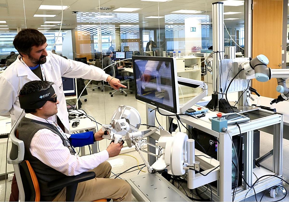 Un investigador explica a uno de los visitantes el funcionamiento de un robot.