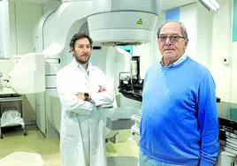 Alfonso Gómez Iturriaga y su paciente Juan José Loredo, junto a un acelerador lineal.