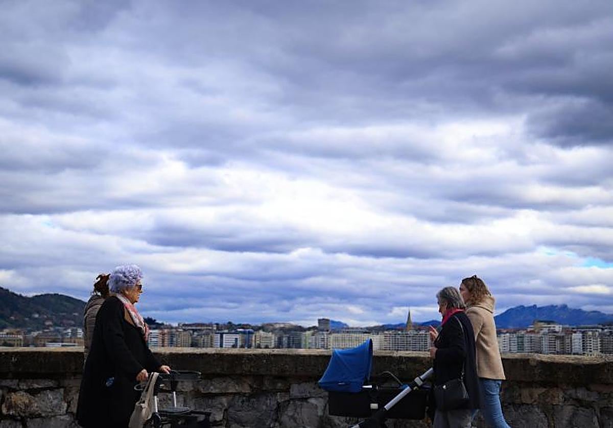 Varias personas caminan por Donostia bajo un cielo cubierto.