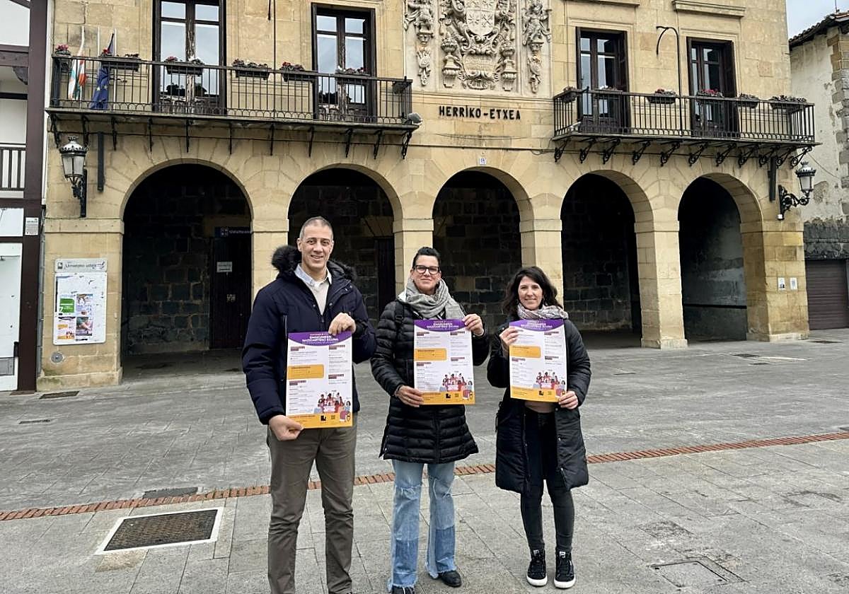 Responsables municipales muestran el cartel que anuncia las actividades organizadas por el 8 de marzo.