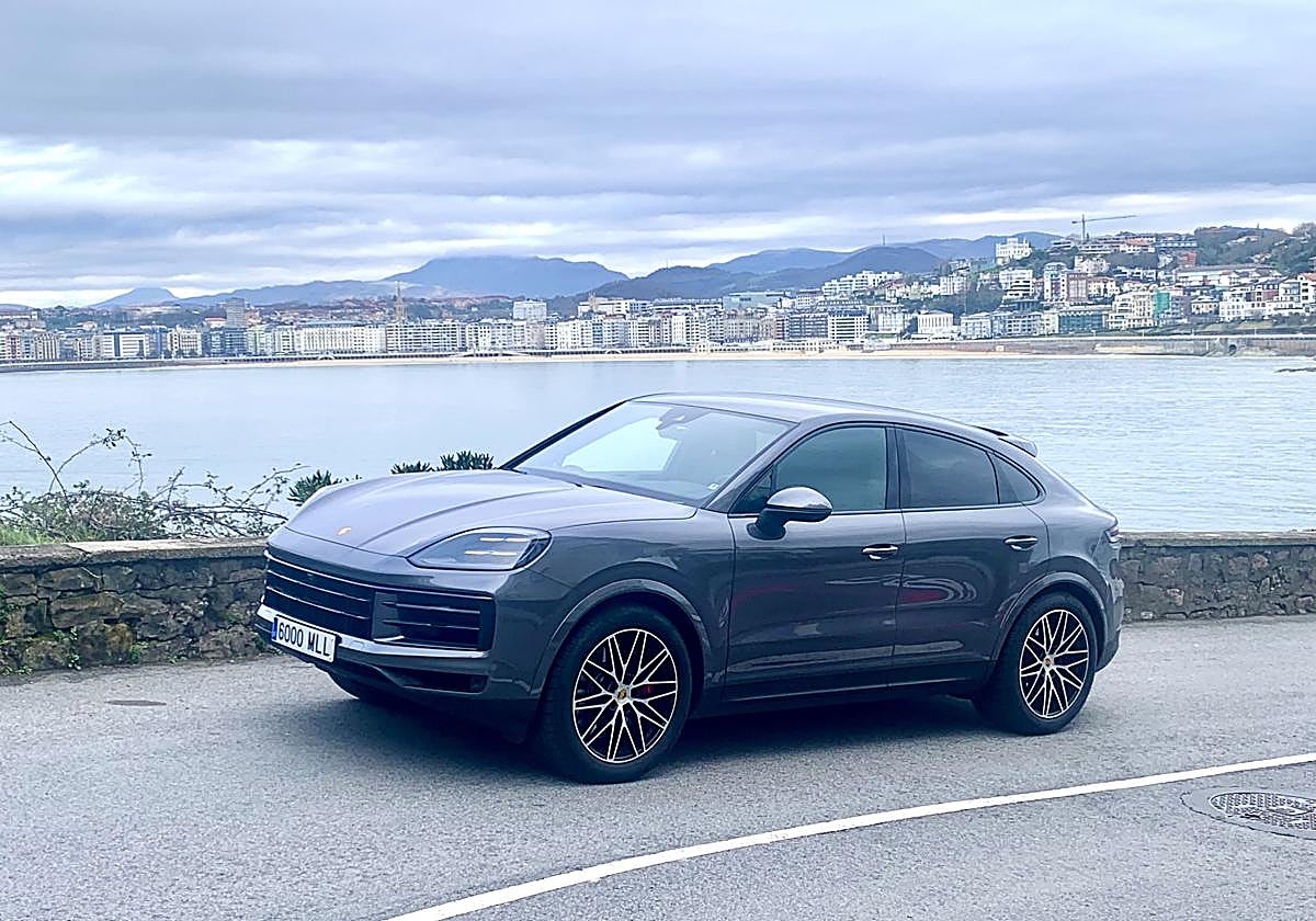 Porsche Cayenne SCoupe con la Bahía de la Concha al fondo. Debajo la trasera y el interior con su enorme pantalla.
