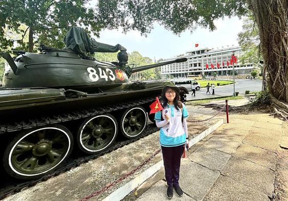 Uns chica vietnamita posa ante el museo de la reunificación de Ho Chi Minh después de «entrevistar» al cronista.