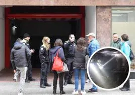 Propietarios de los vehículos, junto con la Policía Municipal, en la puerta del garaje comunitario. Los bomberos sofocan el incendio.