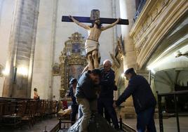 Cuatro voluntarios colocan el sudario de Cristo en un paso que saldrá en la procesión de Viernes Santo en Segura.