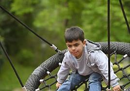Mikel se divierte en los columpios.
