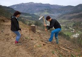 Jone Maioz y Juanjo Oiarbide bromean mientras plantan una secuoya en los terrenos de Segura, con Aizkorri al fondo.