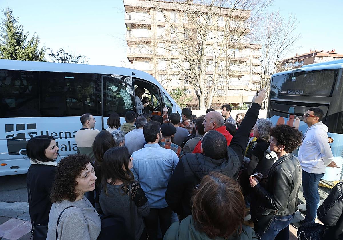Clientes de sidrerías esperan en Hernani a subir al autobús que les lleve a los establecimientos.