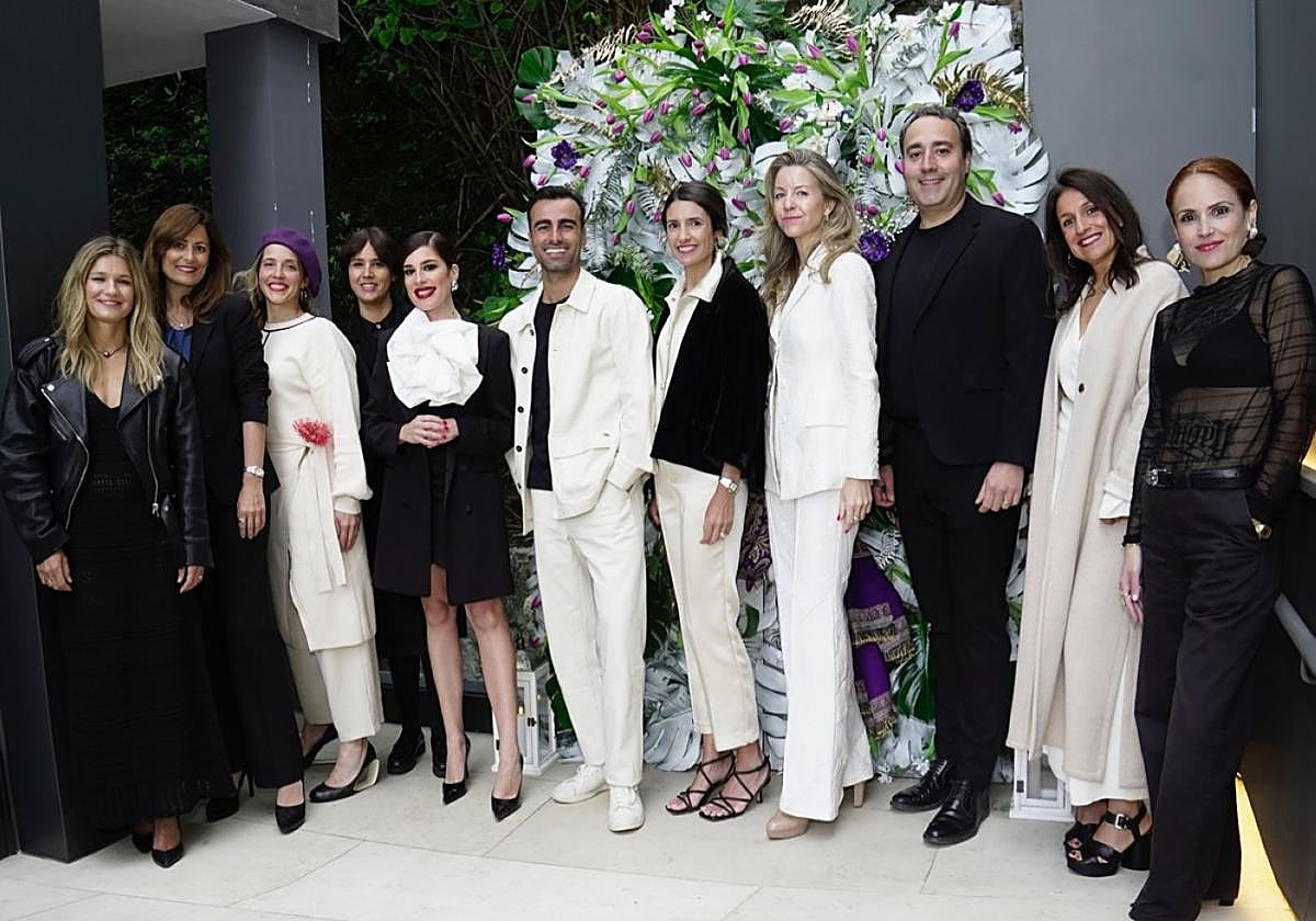 Organizadores, patrocinadores y firmas participantes posan en la entrada a la fiesta.