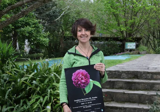 Aran Aldai sostiene el cartel de la feria en las instalaciones del jardín botánico de Iturraran.