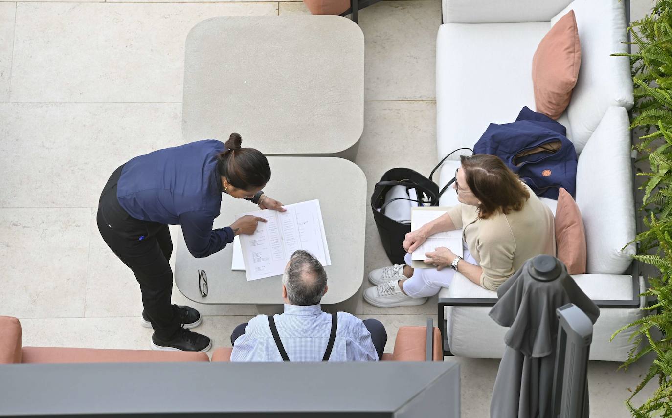 Una camarera de un hotel donostiarra atiende a unos clientes en una terraza