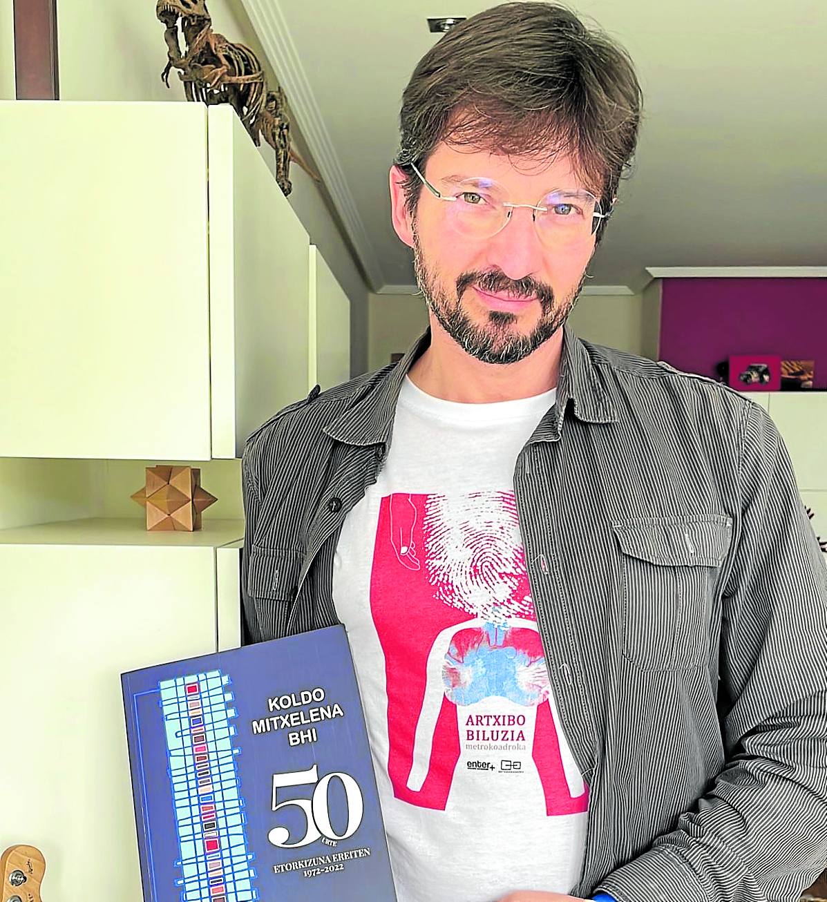 Oscar Picazo sostiene el libro del 50 aniversario de Koldo Mitxelena