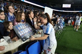 Nerea Eizagirre atiende a un grupo de niñas firmando un póster durante la semifinal de Copa disputada en el Reale Arena