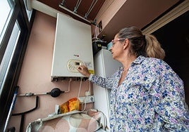 Una mujer regula la caldera en su casa de Irun.