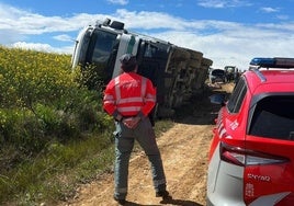 Un policía foral junto al camión volcado en Oteiza.