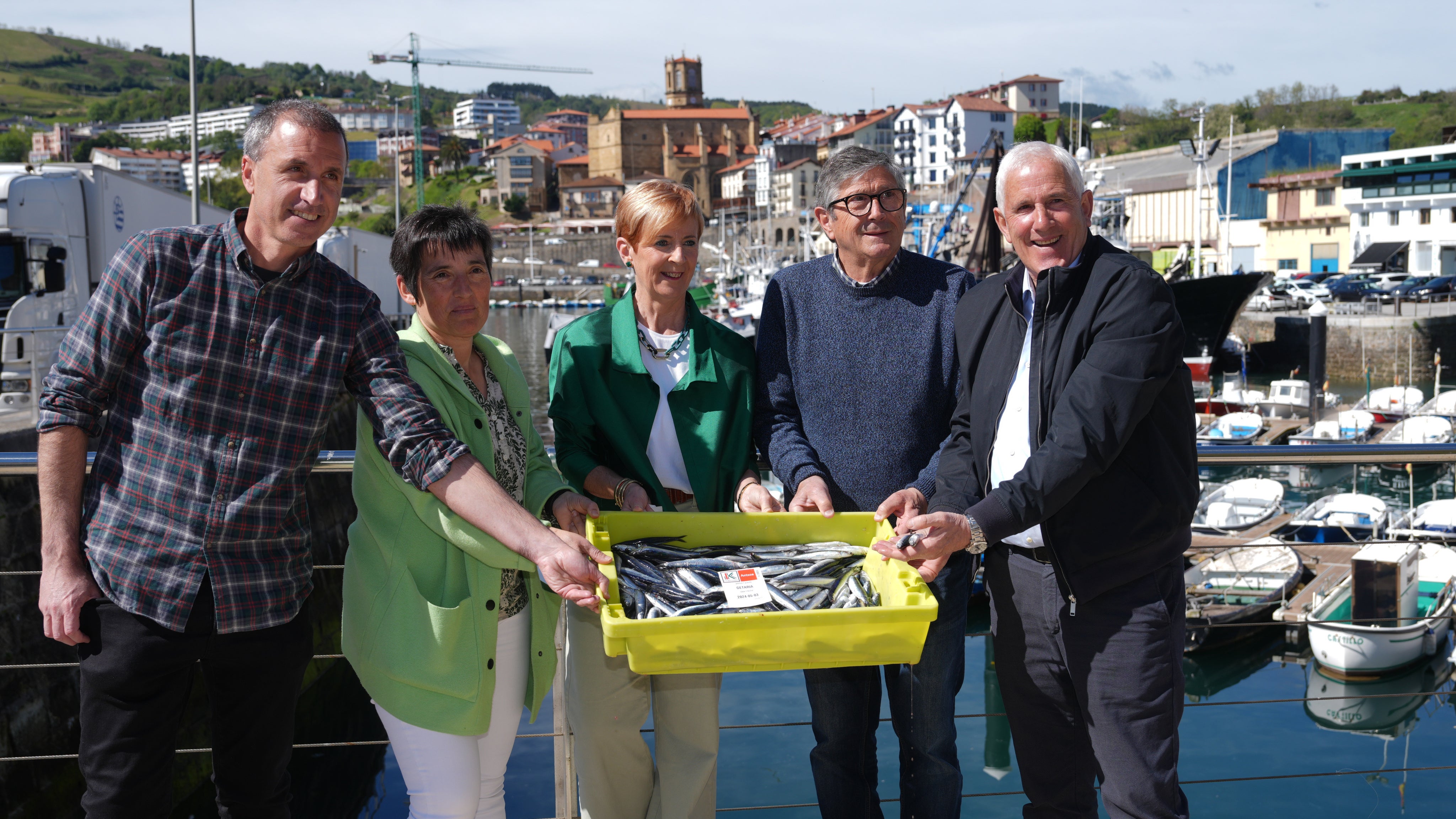 La consejera Arantxa Tapia, en el centro, junto al alcalde de Getaria y representantes de las cofradías, con las anchoas en el puerto de la localidad costera.