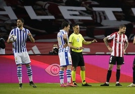 El árbitro Estrada Fernández junto a Oyarzabal e Iñigo Martínez en la final de la Copa del Rey ganada por la Real en abril de 2021.