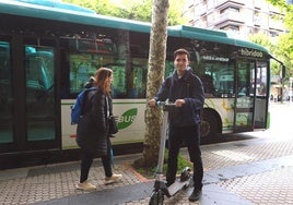 Álvaro Mendo, con su patinete eléctrico junto a un vehículo de Lurraldebus.