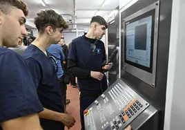 Alumnos del Politécnico de Easo manejando una máquina en una clase práctica.